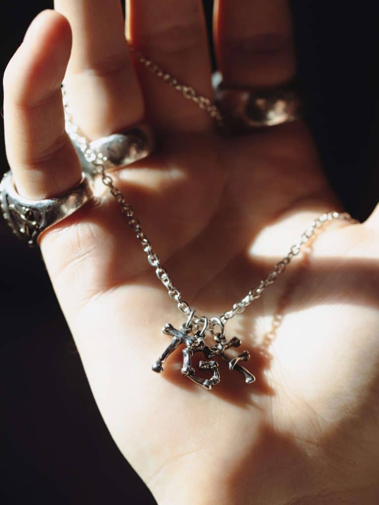 Several TGF Pendants placed in a hand on a chain.