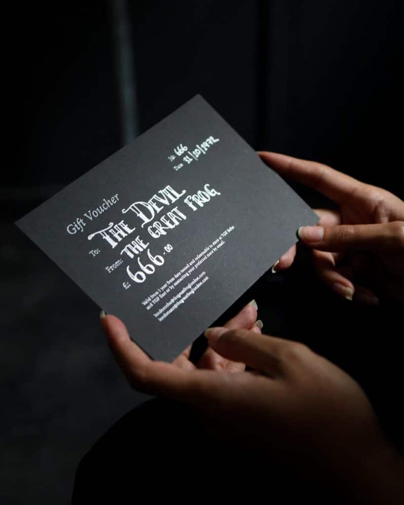 A TGF Gift Voucher being held by a pair of hands.